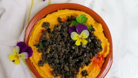 carrot hummus with tapenade and edible flowers