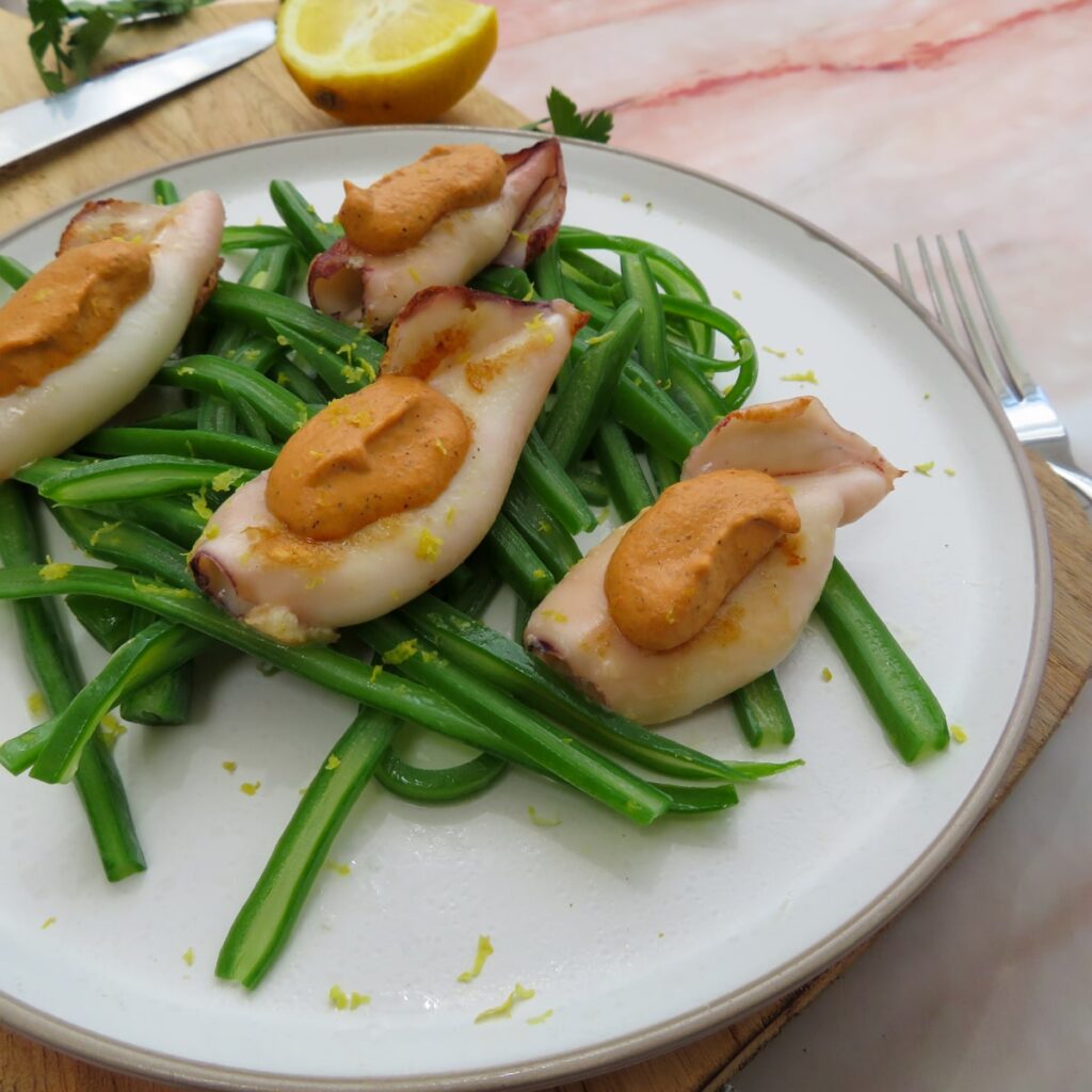 Grilled squid with muhammara and sautéed green beans and lemon zest